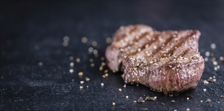 Fresh grilled Beef Steak (selective focus, close-up shot) on dark background