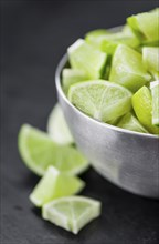 Sliced Limes on a vintage slate slab (close-up shot, selective focus)