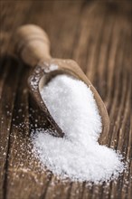 Portion of White Sugar (detailed close-up shot, selective focus) on wooden background