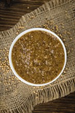 Fresh made German Cuisine (sweet Mustard) on a vintage background (close-up shot)