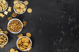 Portion of mixed Snacks on dark background (detailed close up shot, selective focus)