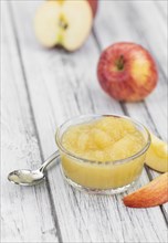 Homemade Applesauce (selective focus, close-up shot) on vintage background with some fresh fruits