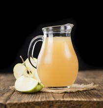 Apple Juice on an old wooden table as detailed close-up shot (selective focus)