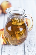 Ice Tea (Peach) on an old wooden table (selective focus, close-up shot)