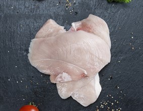 Raw Chicken Cutlet on a slate slab (detailed close-up shot)