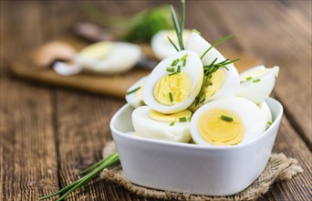 Wooden table with halved Eggs (selective focus, close-up shot)