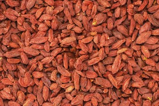 Dried Goji Berries as high detailed close-up shot on a vintage wooden table (selective focus)