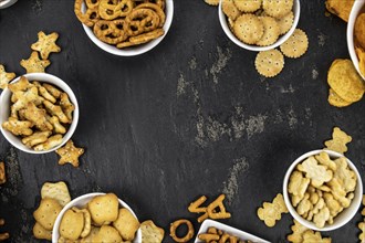 Portion of mixed Snacks on dark background (detailed close up shot, selective focus)