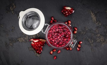 Healthy preserved Pomegranate seeds on a vintage slate slab (close-up shot, selective focus)