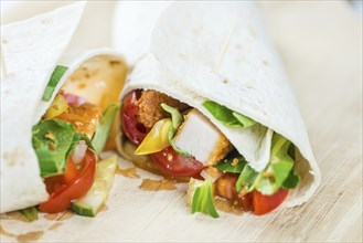 Chicken Wrap (detailed close-up shot, selective focus) on wooden background