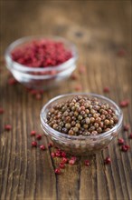 Preserved Pink Peppercorns on a vintage background as detailed close-up shot, selective focus