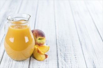 Fresh made Peach juice (detailed close-up shot) on wooden background