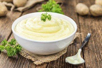 Potato Mash on rustic wooden background (close-up shot)