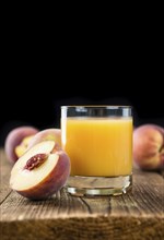 Peach juice (detailed close-up shot) on an old wooden table