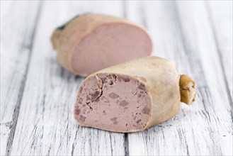 Liverwurst (German cuisine) as high detailed close-up shot on a vintage wooden table (selective