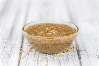 Homemade Sweet Mustard on an wooden table (selective focus) as detailed close-up shot