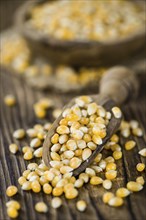 Portion of Corn (detailed close-up shot) on wooden background (selective focus)