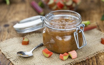 Rhubarb Jam on an old wooden table as detailed close up shot (selective focus)