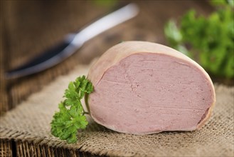 Liverwurst (German cuisine) as high detailed close-up shot on a vintage wooden table (selective