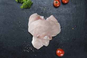 Slate slab with raw Chicken Cutlet (close-up shot)