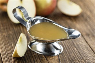 Portion of fresh made Applesauce (selective focus) on wooden background