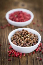 Fresh made Pink Peppercorns (preserved) on an old and rustic wooden table, selective focus,