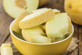 Honeydew Melon on an old wooden table as detailed close-up shot (selective focus)