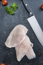 Raw Chicken Cutlet on a slate slab (detailed close-up shot)