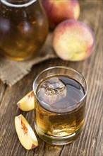 Ice Tea (Peach) on an old wooden table (selective focus, close-up shot)