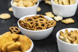 Portion of mixed Snacks on dark background (detailed close up shot, selective focus)