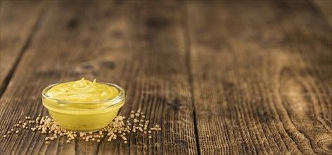 Portion of homemade Mustard on wooden background (selective focus, close-up shot)