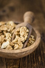 Cracked Walnuts as high detailed close-up shot on a vintage wooden table (selective focus)