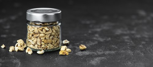 Chopped Hazelnuts on rustic background as close up shot (selective focus)