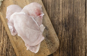 Old wooden table with raw Chicken Cutlet (detailed close-up shot)