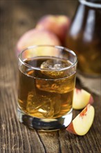 Ice Tea (Peach) on an old wooden table (selective focus, close-up shot)