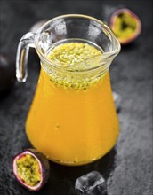 Portion of healthy Maracuja Juice on a slate slab (selective focus)