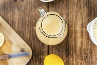 Fresh made Juice (lemon) on an old and rustic wooden table (selective focus, close-up shot)