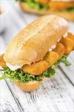 Sandwich with Fish Sticks (selective focus) on an old wooden table