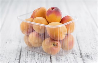 Apricots on an old wooden table as detailed close-up shot (selective focus)