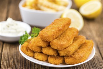 Fisch Sticks (close-up shot) on an old wooden table (selective focus)