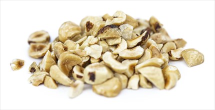 Freshly chopped Hazelnuts as detailed close up shot isolated on white background (selective focus)