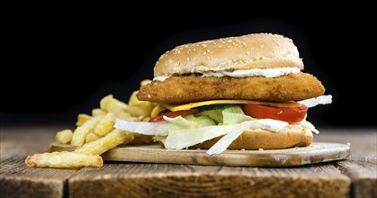 Homemade Fish Burger (close-up shot, selective focus) on a wooden table