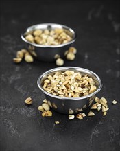 Freshly chopped Hazelnuts as detailed close up shot (selective focus)