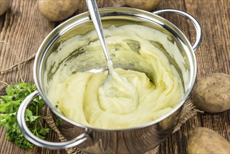 Portion of homemade Mashed Potatoes on wooden background (selective focus, close-up shot)