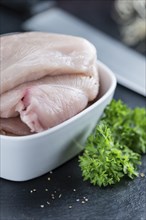 Raw Chicken Cutlet on a slate slab (detailed close-up shot)