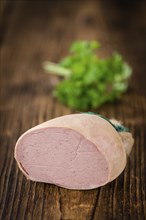 Liverwurst (German cuisine) as high detailed close-up shot on a vintage wooden table (selective