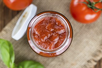 Homemade Tomato Ketchup on an wooden table (selective focus) as detailed close-up shot