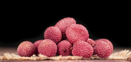 Litchis on an old wooden table as detailed close-up shot (selective focus)