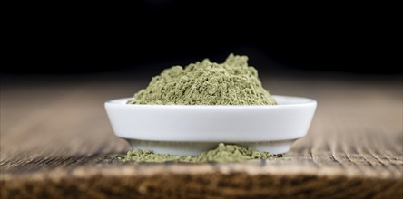 Heap of Stevia (powder) on an old wooden table (close-up shot)