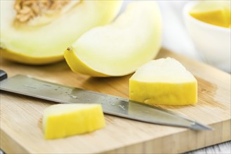 Fresh made Yellow Honeydew Melon on a vintage background (close-up shot)